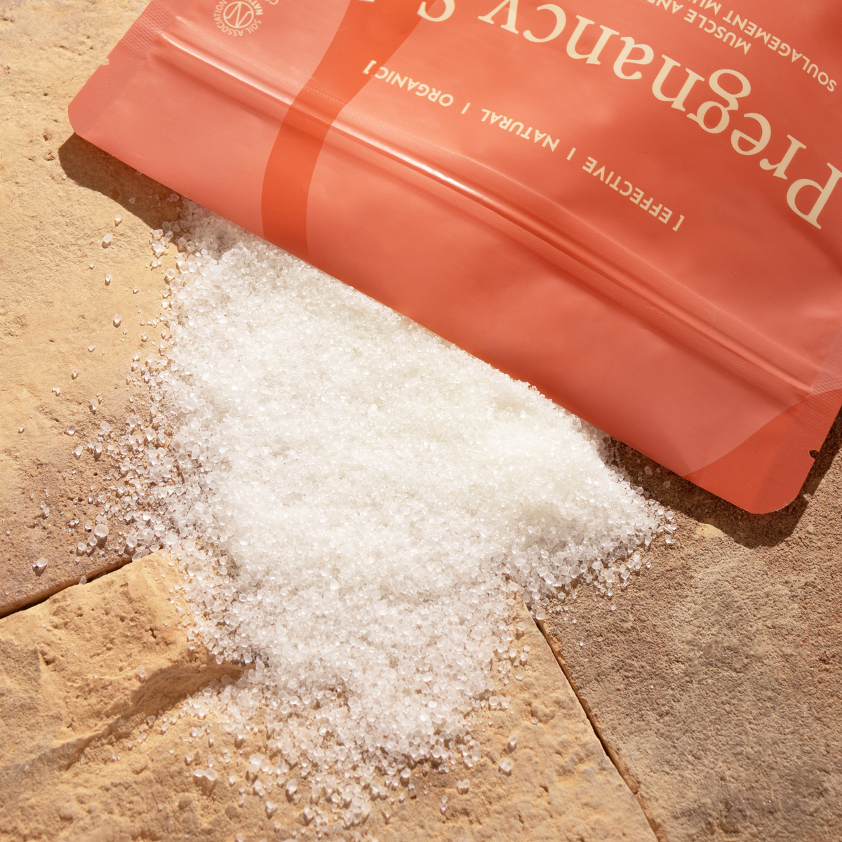 Wholyme Pregnancy Salts mit weissen Salzkristallen neben dem Beutel